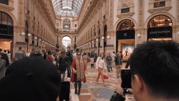 Milan, Olaszország-május 2019: ázsiai turisták képeket központjában Vittorio Emanuele galériában. A koncepció a bevásárló-és drága luxus üzletek. Lassított mozgás — Stock videók