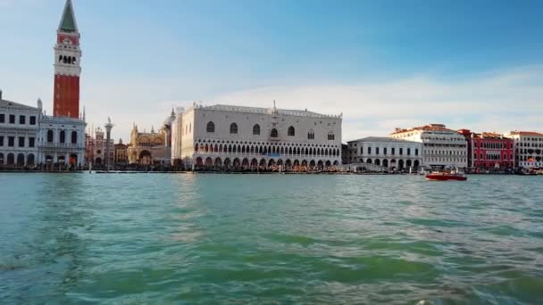 VENICE, Itália - Maio de 2019: Piazza San Marco. As principais atrações de Veneza a partir da água. Um barco marrom está se movendo rapidamente ao longo das ondas contra o fundo do Palácio dos Doges. Movimento lento — Vídeo de Stock