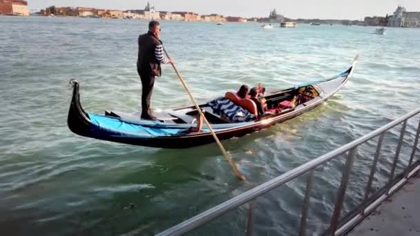 Venedig, Italien - Mai 2019: Junges verliebtes Paar macht Selfie auf dem Smartphone, während es in einer Gondel sitzt. Gondoliere kommen mit starken Wellen zurecht. das Boot schaukelt. Zeitlupe — Stockvideo