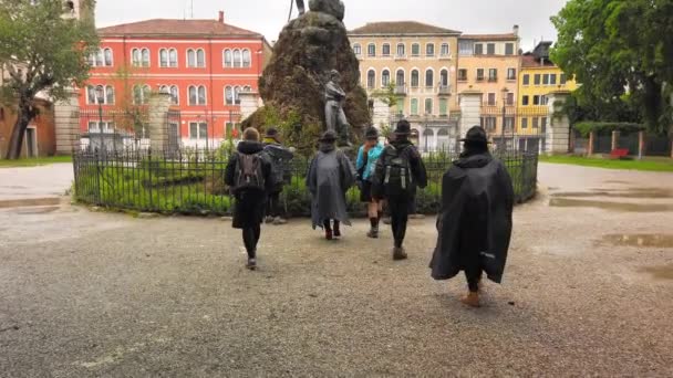 Venedig, Italien - Mai 2019: Pfadfindermädchen in Hüten und Regenmänteln erkunden die Natur in der Nähe eines Teiches und Denkmals in Europa. Zeitlupe — Stockvideo