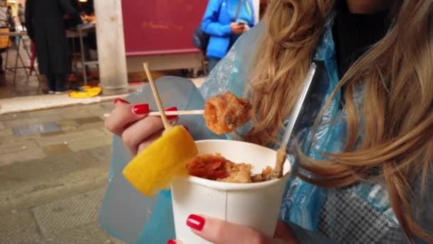 VENECIA, Italia - Mayo 2019: La joven americana disfruta y come mariscos a la parrilla en un mercado en el centro de Venecia. Movimiento lento — Vídeo de stock