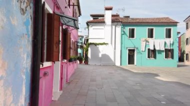Burano, Venedik, İtalya - Mayıs 2019: Venedik lagünü adalarından birinin tipik avlusu ve renkli evleri. Kıyafetler çamaşır ipinde kurutulur. Yavaş çekim