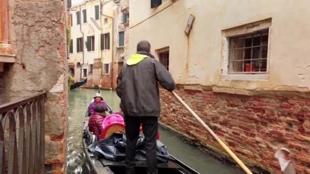 VENICE, Itália - Maio de 2019: turistas multirraciais asiáticos desfrutam de um passeio de gôndola pelo estreito canal de Veneza. Movimento lento — Vídeo de Stock