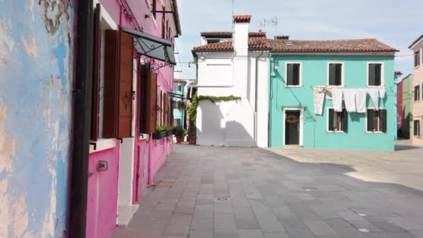 Burano, Βενετία, Ιταλία-Μάιος 2019: χαρακτηριστική αυλή και πολύχρωμα σπίτια ενός από τα νησιά της βενετσιάνικης λίμνης. Τα ρούχα ξηραίνονται στο σχοινί. Αργή κίνηση — Αρχείο Βίντεο