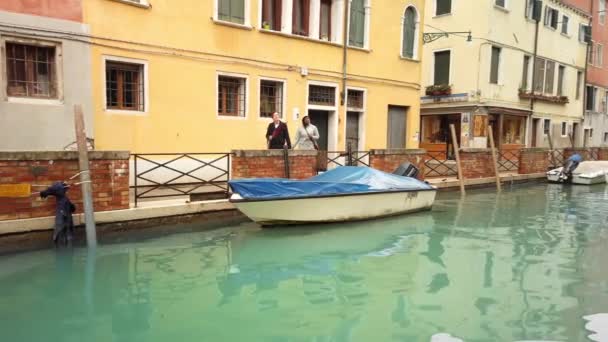 VENICE, Itália - Maio 2019: jovem casal de turistas multirraciais explorando os pontos turísticos. Conceito de amor sem sinais raciais. Contra o fundo do canal e do barco. Movimento lento . — Vídeo de Stock