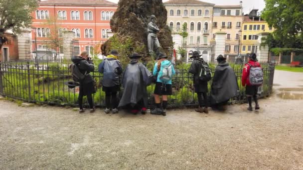 Venedig, Italien - Mai 2019: Truppe von Pfadfindermädchen in Regenmänteln und Hüten erkundet die Natur. Beobachten Sie den Teich und fotografieren Sie mit der Kamera. Zeitlupe — Stockvideo