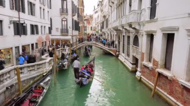 Venedik, İtalya - Mayıs 2019: Köprüde çok turist var. Dar kanallar, sokak. Gondollar turist taşır. Tipik Venedik manzarası. Yavaş çekim