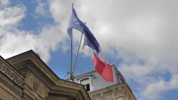 Frankrikes och Europeiska unionens flagga. Vågor i vinden på en flaggstång. Ligger på en traditionell Okänd fransk byggnad. Slow motion — Stockvideo