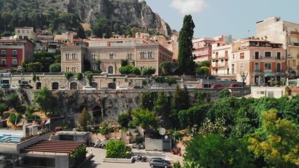 Taormina, Sicilya, İtalya - Ağustos 2019: kayalık dağlarda bulunan güzel dağ kasabası. Arka planda bir volkan var. Tanınmayan mağazalar ve havuz taşıma ile tanınmayan pahalı oteller — Stok video