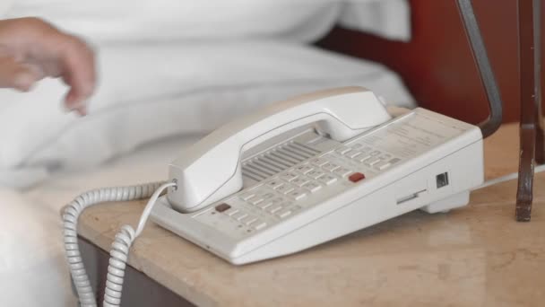 Ismeretlen felnőtt idős nő egy fehér fürdőköpeny felveszi a telefont a szállodai szobában, és úgy a hívást. Lassított mozgás, Bezárás — Stock videók