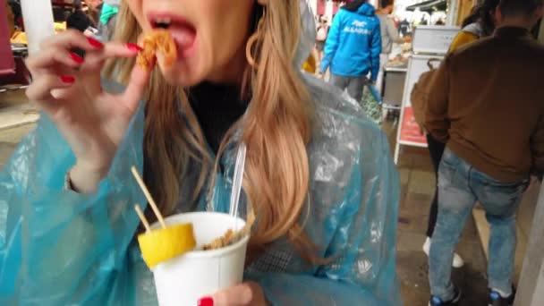 VENICE, Italy - May 2019: Beautiful girl eats grilled shrimp with her hands. In the seafood market. slow motion — Stock Video