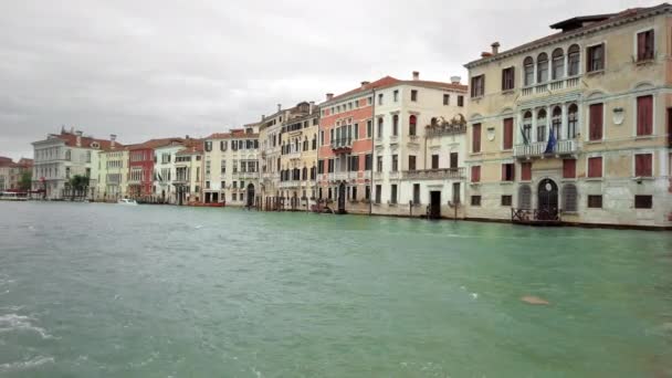 Βενετία, Ιταλία-2019 Μαΐου: τυπικός Βενετσιάνος δρόμος. Παλιά σπίτια που πήγαιναν στο νερό. Ένα βαπορέτο περνά με μια διαφήμιση για την Μπιενάλε της Βενετίας. αργή κίνηση — Αρχείο Βίντεο