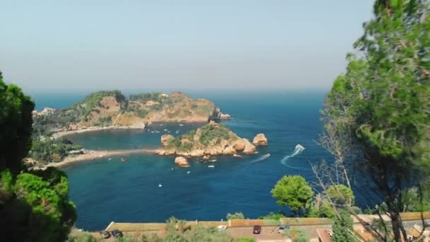 Taormina, SICILIA, Italia - Agosto 2019: Paraíso. Playa - el océano está rodeado de montañas y acantilados. Muchos árboles. Rastreadores de yates en el agua. Disparo aéreo con drones — Vídeo de stock