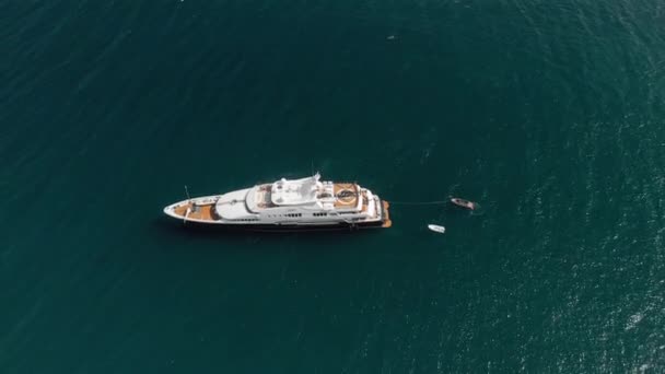 Taormina, sizilien, italien - august 2019: ein riesiges Luxusjachtboot mit Hubschrauberlandeplatz und Hubschrauber darauf. Korruption, großes Geld, Luxusleben. Drohnenschuss aus der Luft — Stockvideo