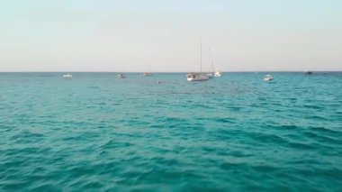 açık deniz üzerinde kamera slaytlar. Yelkenli yat ve tekne direkleri üzerinde yükselir. Arka planda ufuk çizgisi. Havadan insansız hava aracı vuruldu