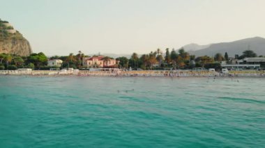 Palermo, Sicilya, İtalya - Küçük evler ve deniz birçok ağaç. Tanınmayan turistler suda yüzüyor. Plaj ve Akdeniz Resort. Havadan insansız hava aracı vuruldu.