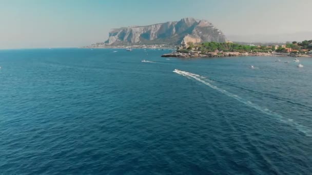 Isla tropical, muchos árboles y vegetación. El barco cabalga sobre el océano. Gran montaña detrás. Disparo aéreo con drones — Vídeos de Stock