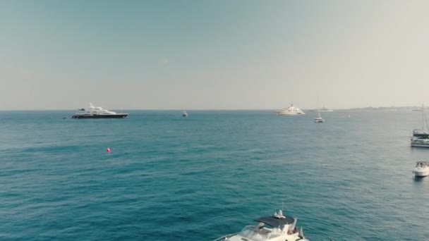 Ontspan op een jacht op een warme zomerdag. De camera beweegt vooruit, veel boten in het blauwe water van de Oceaan. Luchtfoto van Drone. — Stockvideo