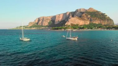 Akdeniz'de kayalık bir adanın yanında demirlemiş çok sayıda turistik yat. Havadan insansız hava aracı vuruldu