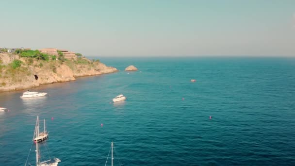 Yates de vela y barcos turísticos en el agua turquesa del océano. Cerca de la isla. Disparo aéreo con drones — Vídeo de stock