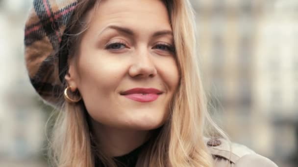 Стильная парижская бизнесвумен в берете и бежевом плаще застенчиво улыбается в камеру. портрет — стоковое видео