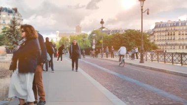 Paris, Fransa - Eylül 2019: Tipik Paris sokağı gün batımında. Yerel halk ve turistler yürüyor. Bisikletçiler ve arabalar geçiyor. Arka planda tipik Paris evleri var.