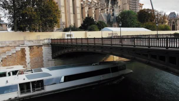 Parijs, Frankrijk - september 2019: cruiseschip vaart langs de Seine bij Notre-Dame de Paris. Renovatie van de aangetaste kathedraal door de brand — Stockvideo