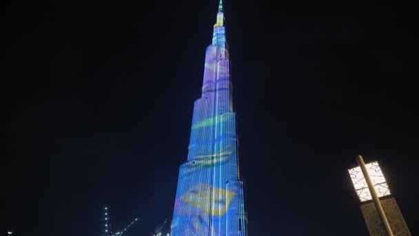 Dubai, Verenigde Arabische Emiraten - Februari 2020: Verlichting van duizenden LCD op het hoogste gebouw ter wereld. Burj Khalifa tegen de achtergrond van Dubais wolkenkrabbers — Stockvideo