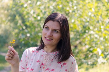 Portre kız açık havada. Temiz hava kır çiçekleri ile doğanın bir arka plan bir güneşli yaz gününde güzel rahatlatıcı kadının