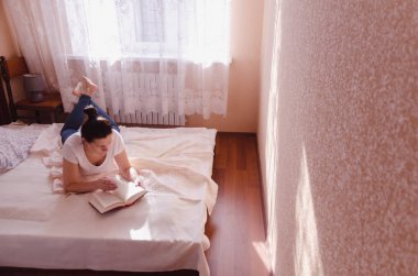 Güneşli bir sabahta, sıcak bir yatak odasında genç bir kadın..