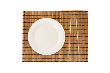 Boş beyaz tabak yemek çubukları ile üstten görünüm ahşap yer mat, beyaz arka plan üzerinde izole.