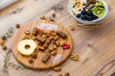 En iyi görünümü ile ahşap tabakta meyve, fındık ve karma gıda.