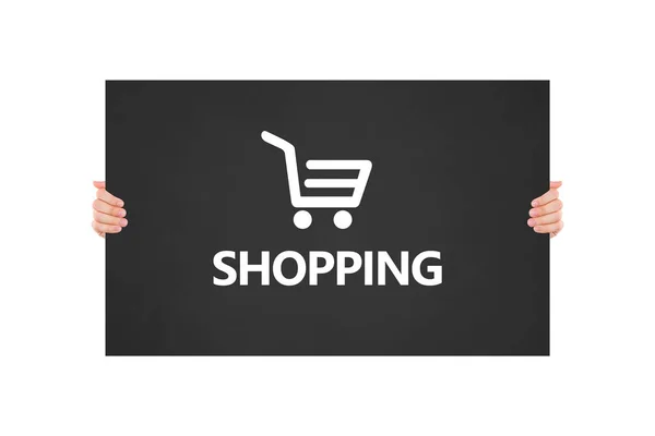 Hand hållande shopping ikon och text på svart tavla — Stockfoto