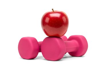 3 boyutlu parlak kırmızı elmaların pembe halterlerle birleştirilmesi, beyaz arka planda izole edilmiş, sağlıklı yaşam tarzını, zindelik motivasyonunu ve fiziksel refah için dengeli beslenmeyi sembolize ediyor..