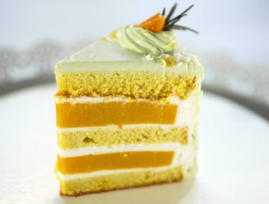 Beyaz arka planda bir tabakta üçgen şeklinde bir pasta.