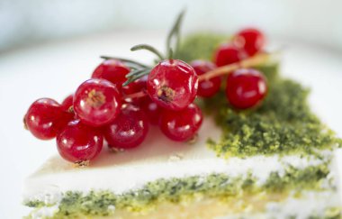 Beyaz arka planda bir tabakta üçgen şeklinde bir pasta.