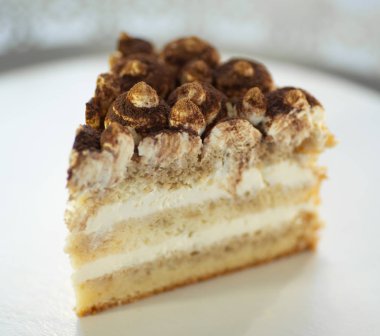 Beyaz arka planda bir tabakta üçgen şeklinde bir pasta.