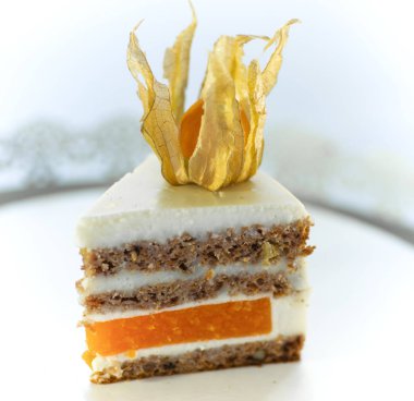 Beyaz arka planda bir tabakta üçgen şeklinde bir pasta.