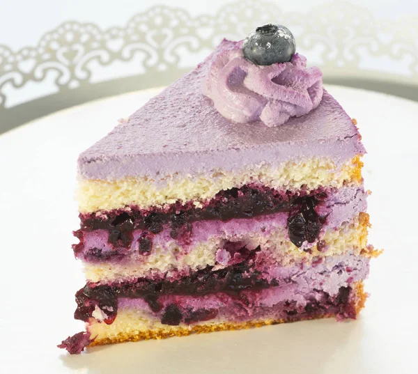 Pedazo de pastel triangular en un plato sobre un fondo blanco — Foto de Stock