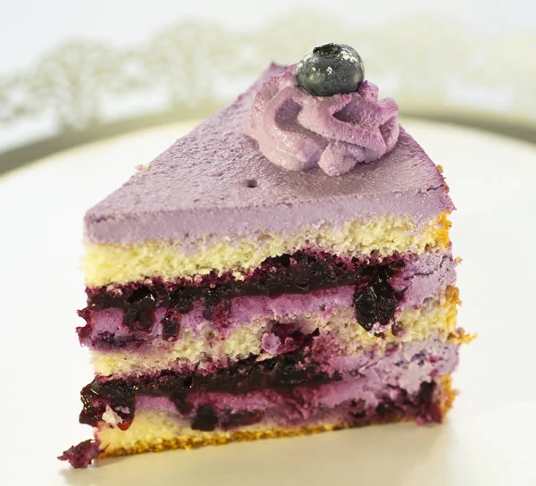 Pedazo de pastel triangular en un plato sobre un fondo blanco — Foto de Stock
