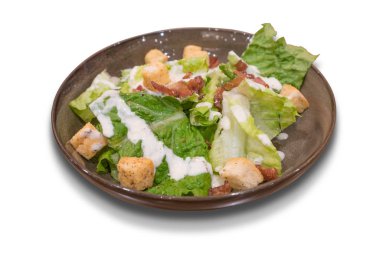 Tabak beyaz arka plan üzerinde izole pastırma ile geleneksel Sezar salatası.