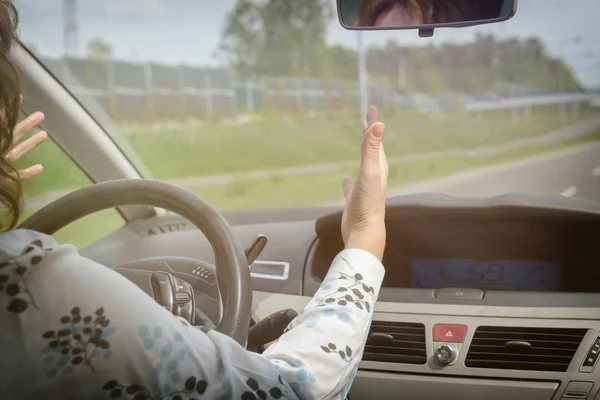 Mujer enojada haciendo gestos mientras conduce un coche —  Fotos de Stock