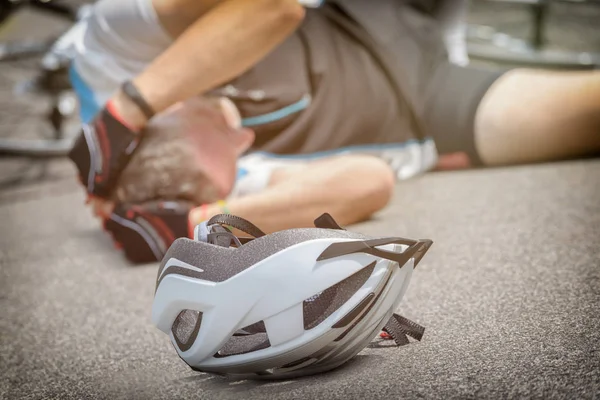 Велосипедист Лежит Дороге Держит Голову Шлем Переднем Плане — стоковое фото