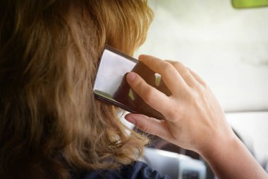 Araba kullanırken telefonu kullanan bir kadın. Tehlikeli sürüş davranışları konsepti