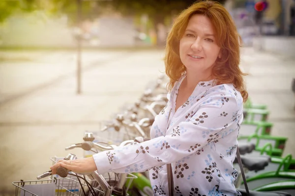 女性都市自転車共同利用駅からレンタル自転車を笑顔 — ストック写真