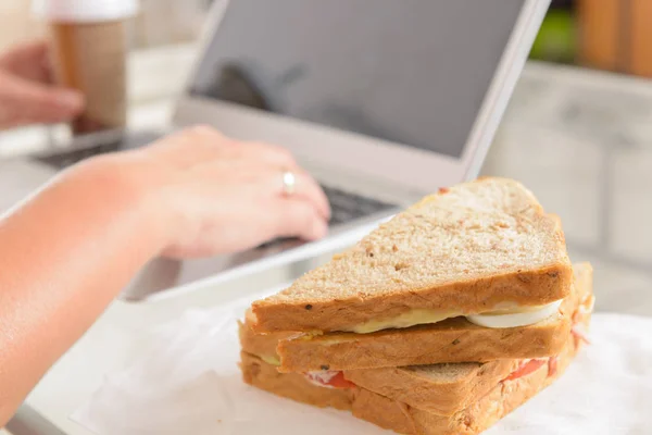 Frau Isst Frühstückssandwich Und Trinkt Kaffee Während Sie Mit Einem — Stockfoto