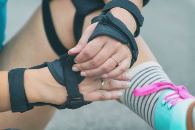 Bileğine koyarak kadın rollerskater elini koruyucu yastıkları korur