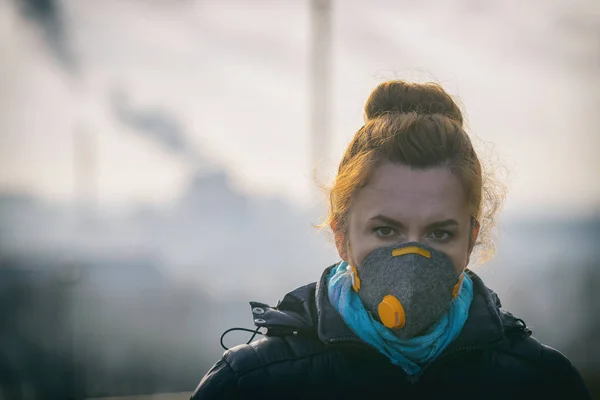 Woman wearing a real anti-pollution, anti-smog and viruses face mask; dense smog in air.