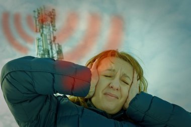 Kadın kafasını Bts. zararlı radyasyon hücresel ağ vericileri konseptinden yakınındaki tutuyor