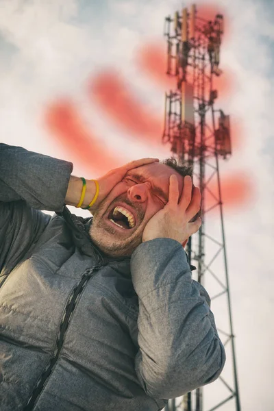 男子在 Bts 附近抱着头 来自蜂窝网络发射机的有害辐射概念 — 图库照片